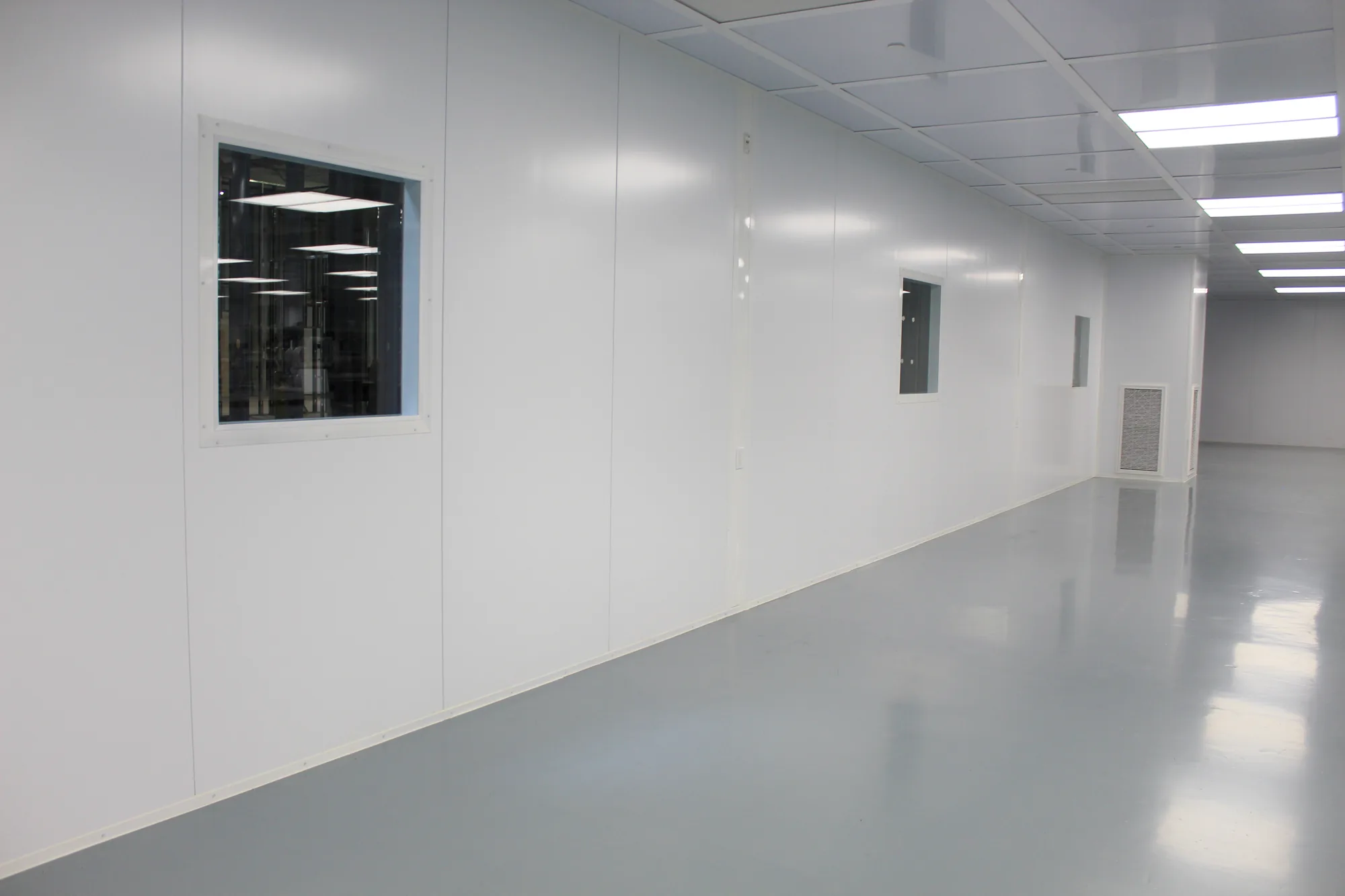 Corridor formed by modular wall panels with observation windows